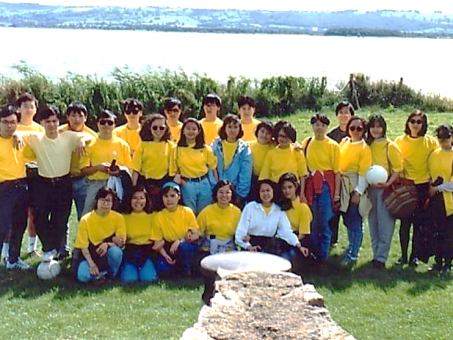 A group of people wearing yellow shirts are posing for a picture