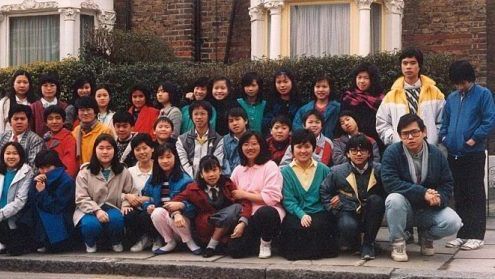 一群人在一棟房子前擺姿勢拍照