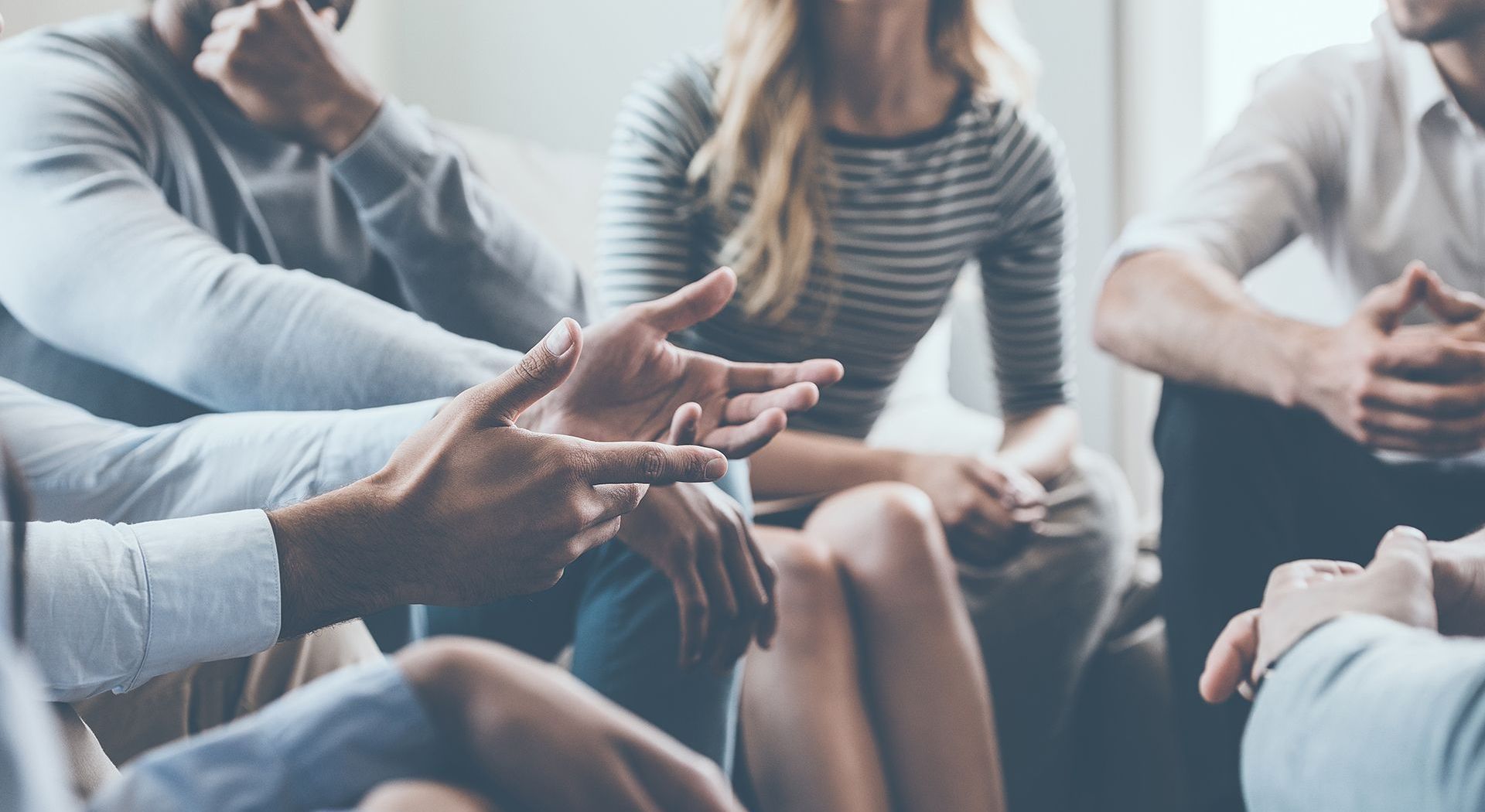 a group of people are sitting in a circle talking to each other .