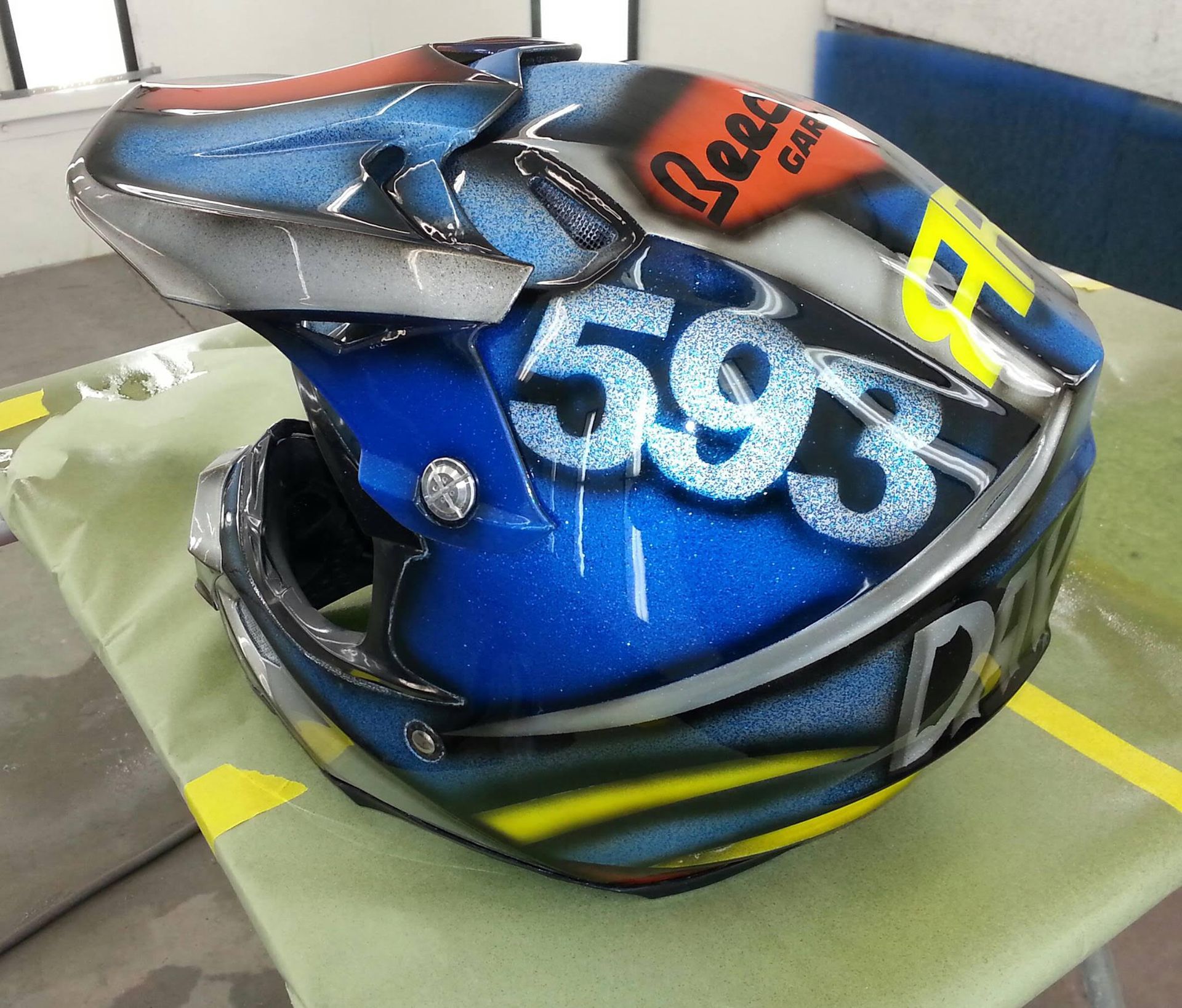 Blue, airbrushed motorcycle helmet with the number 593 and the word 