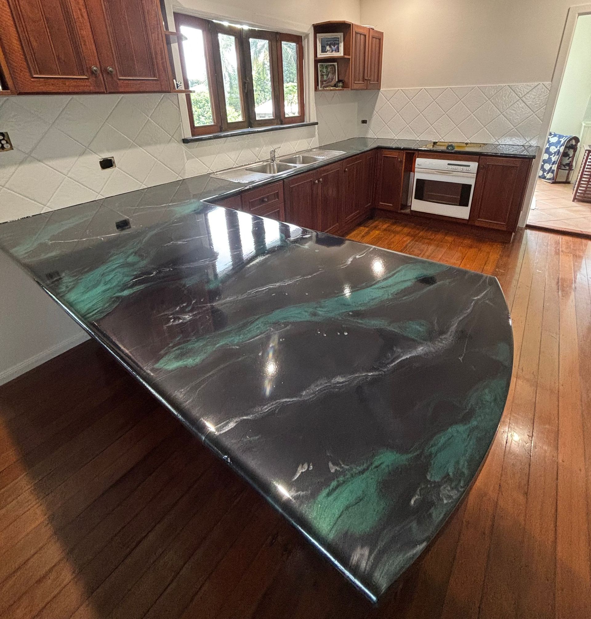 A Person is Using a Trowel to Spread Yellow Paint on a Wooden Floor — Supremacy Painting Co In White Rock, QLD