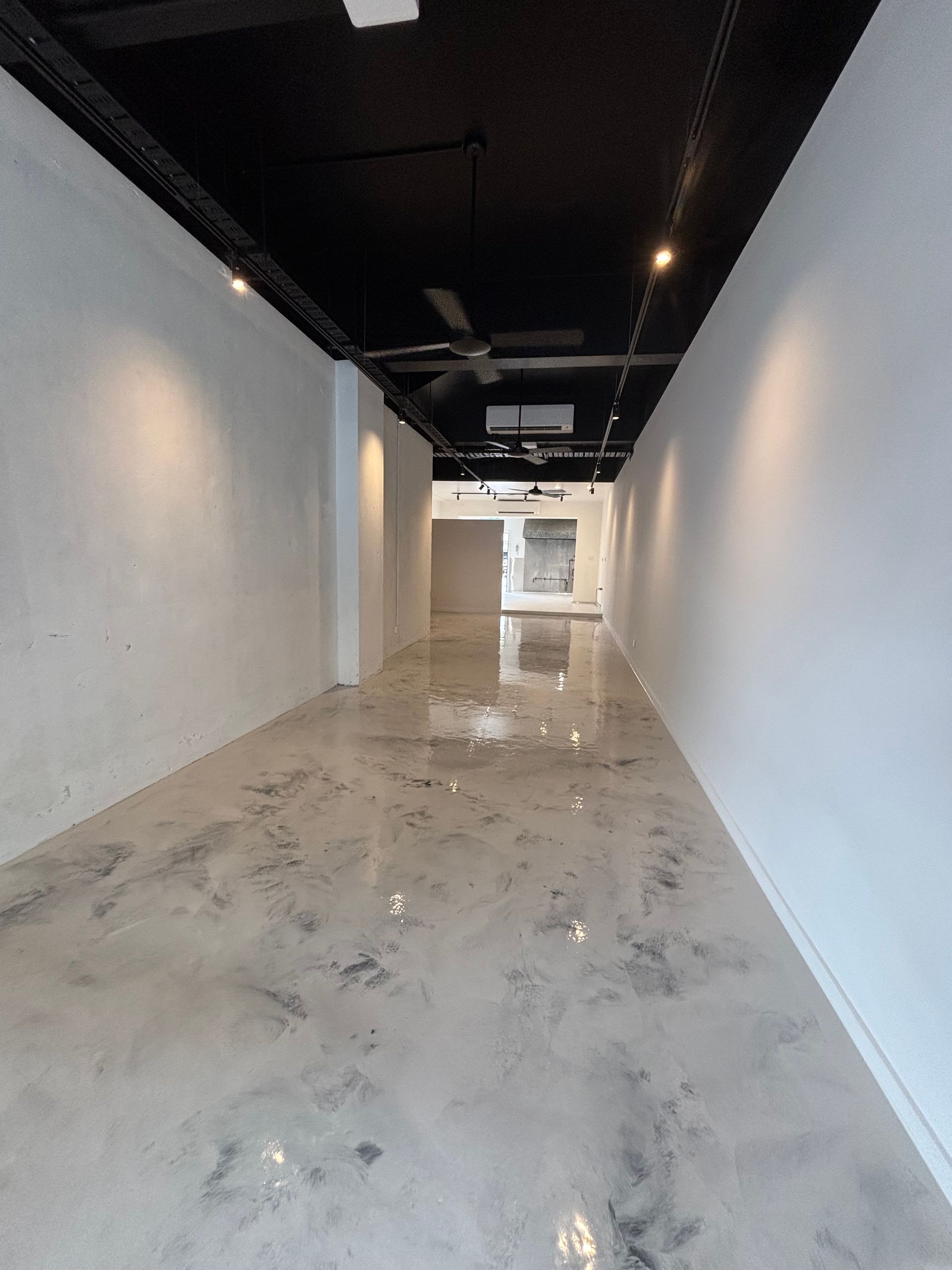 A Person is Painting a Concrete Surface With a Roller — Supremacy Painting Co In White Rock, QLD