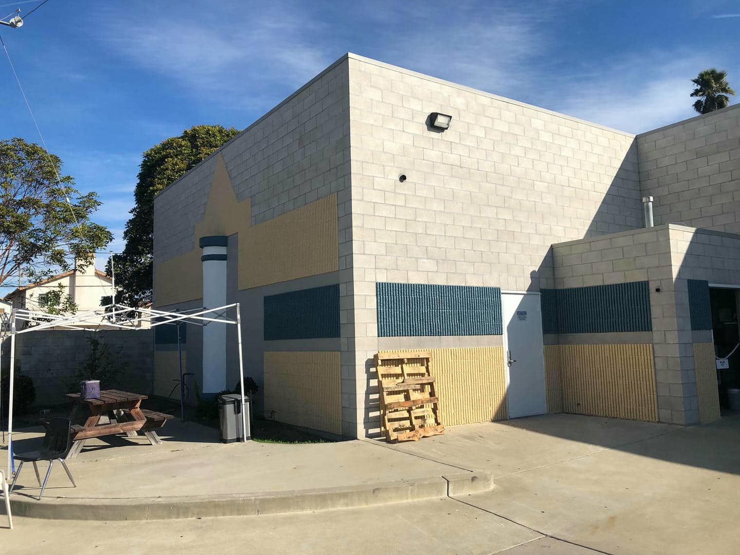 A large brick building with a picnic table in front of it.