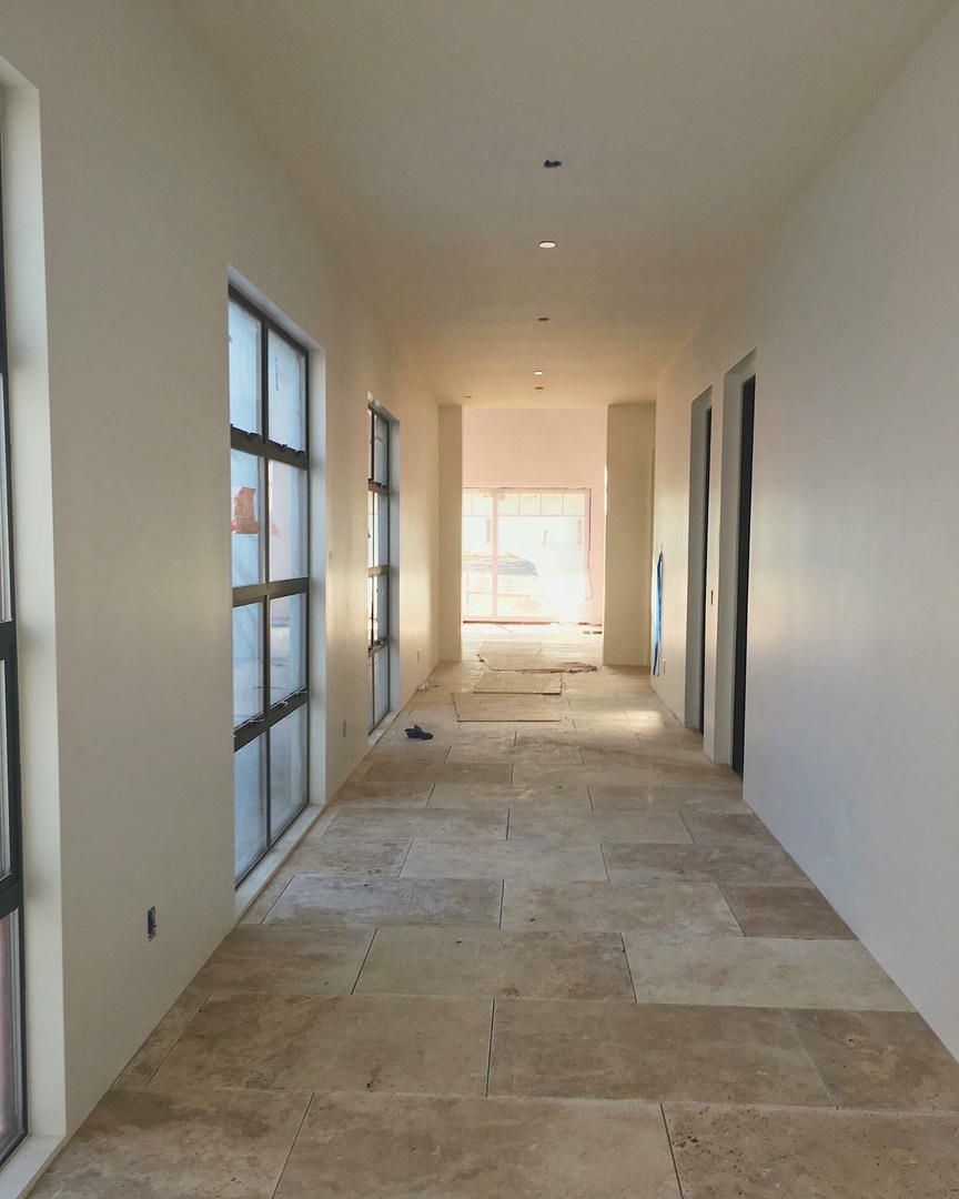 A long hallway with tile floors and white walls