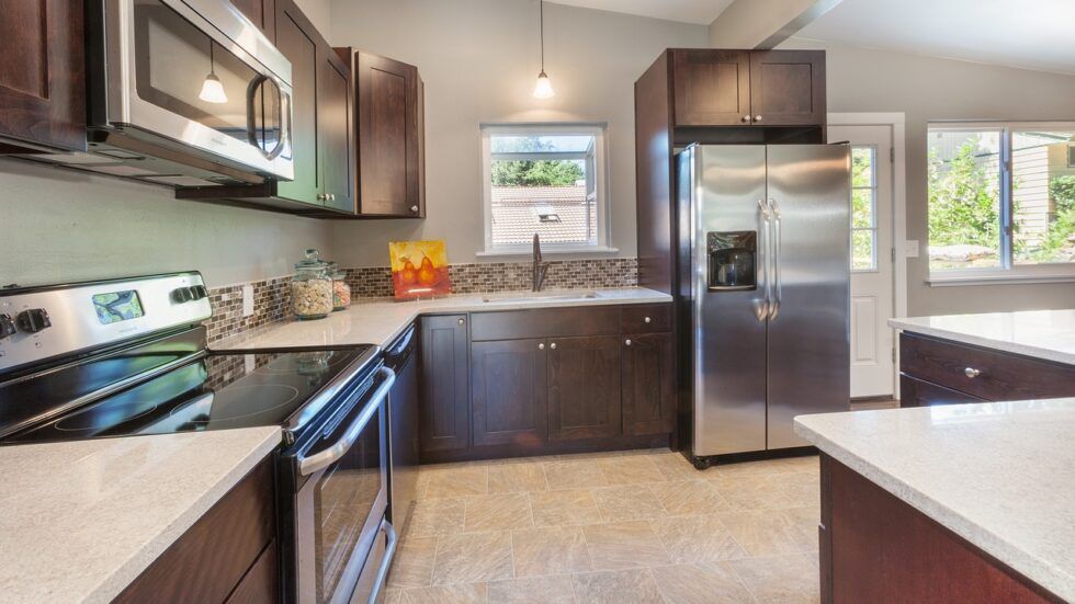 A kitchen with stainless steel appliances and wooden cabinets.