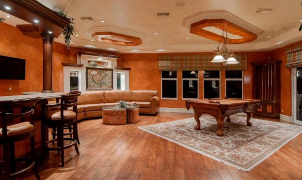 A living room with a pool table and a couch