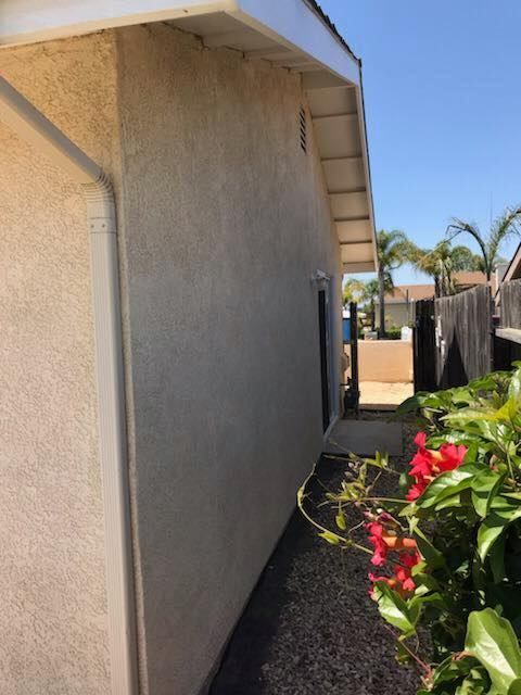 A side view of a house with flowers in front of it