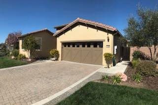 A house with a garage and a driveway in front of it.