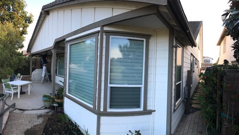 A white house with a large bay window and a patio