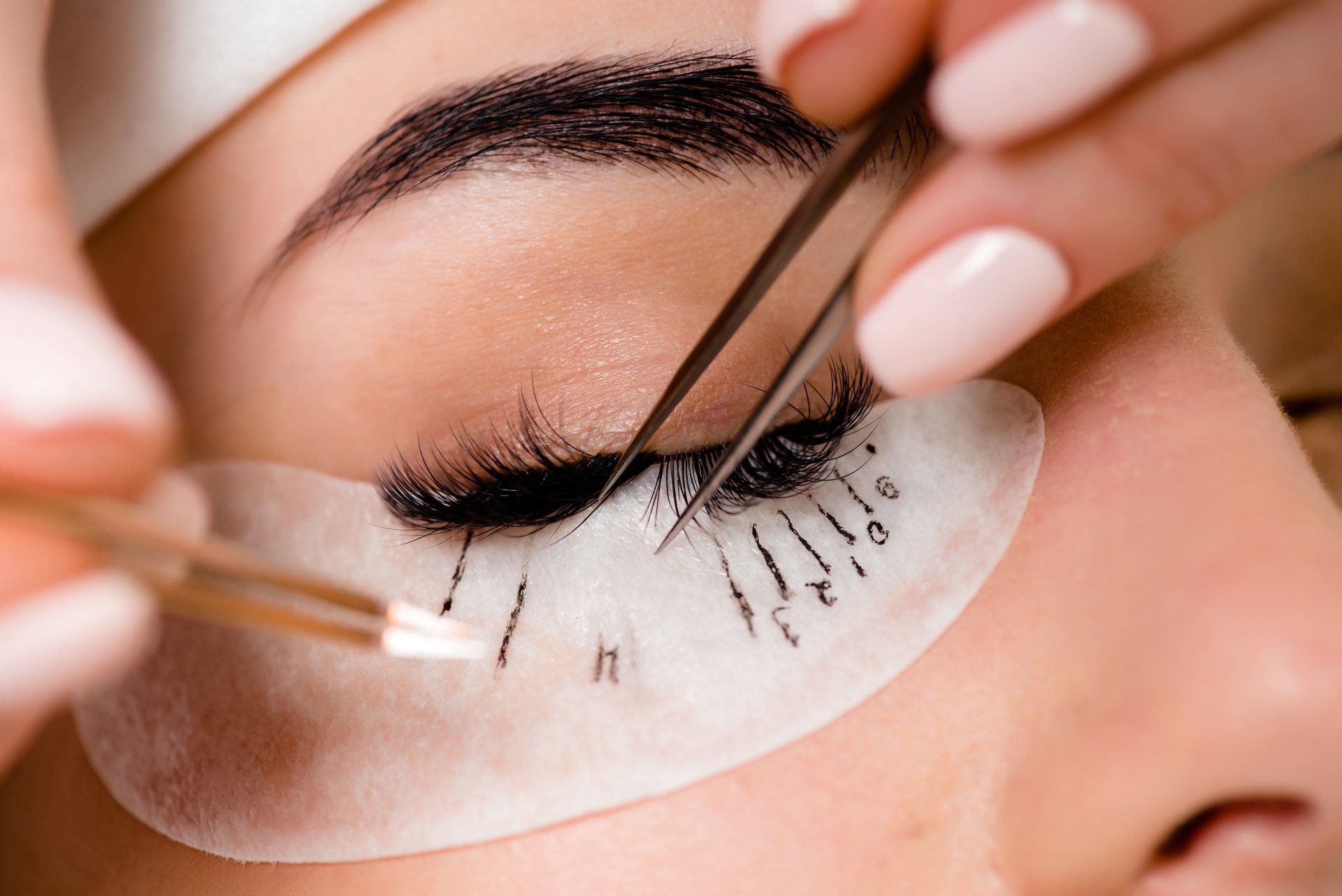 Nahaufnahme einer Frau, die sich Wimpernverlängerungen machen lässt