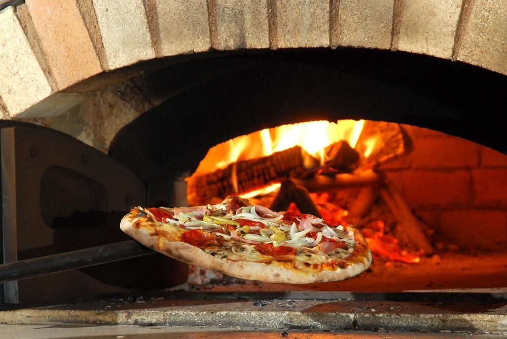 A Pizza Is Being Cooked in A Brick Oven — Gungahlin Kebab and Pizza in Gungahlin, ACT