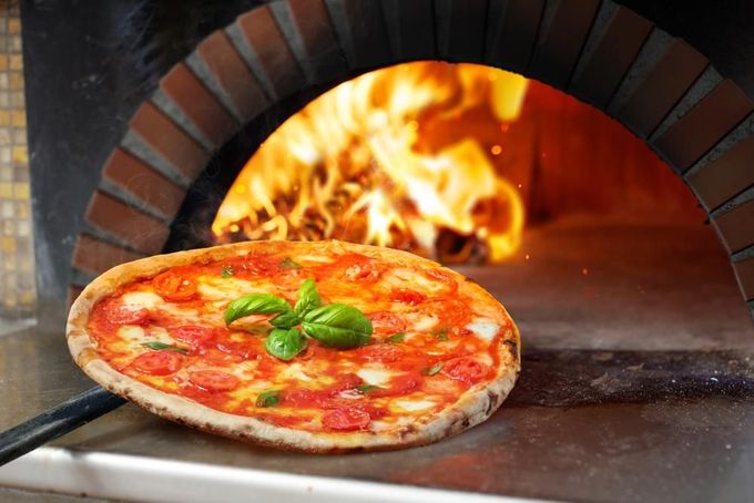A Pizza Is Being Cooked in A Brick Oven — Gungahlin Kebab and Pizza in Gungahlin, ACT