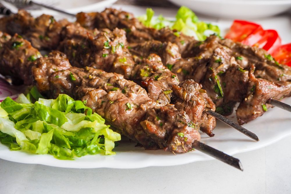 A White Plate Topped with Ribs and Parsley on A Table — Gungahlin Kebab and Pizza in Gungahlin, ACT