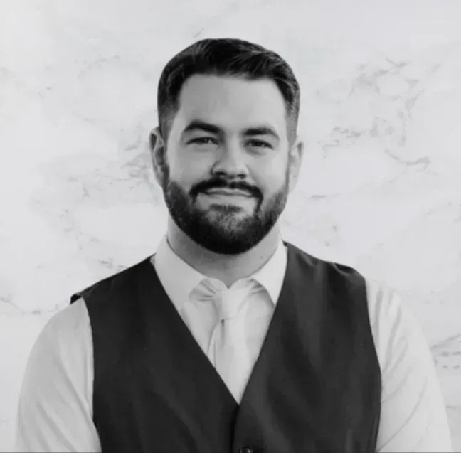 A man with a beard is wearing a vest and tie.