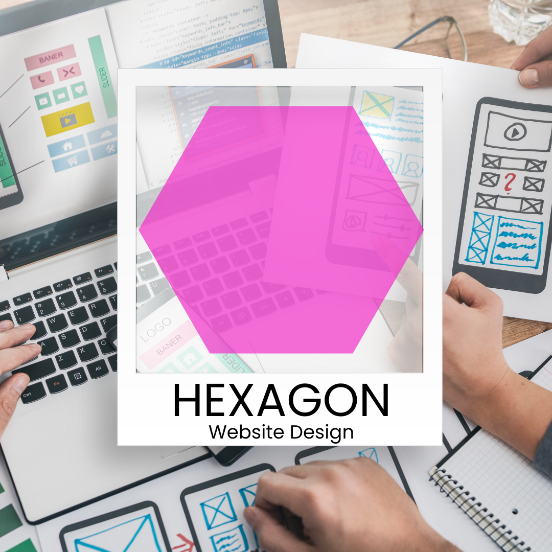 A person is sitting at a desk with a laptop and a pink hexagon.