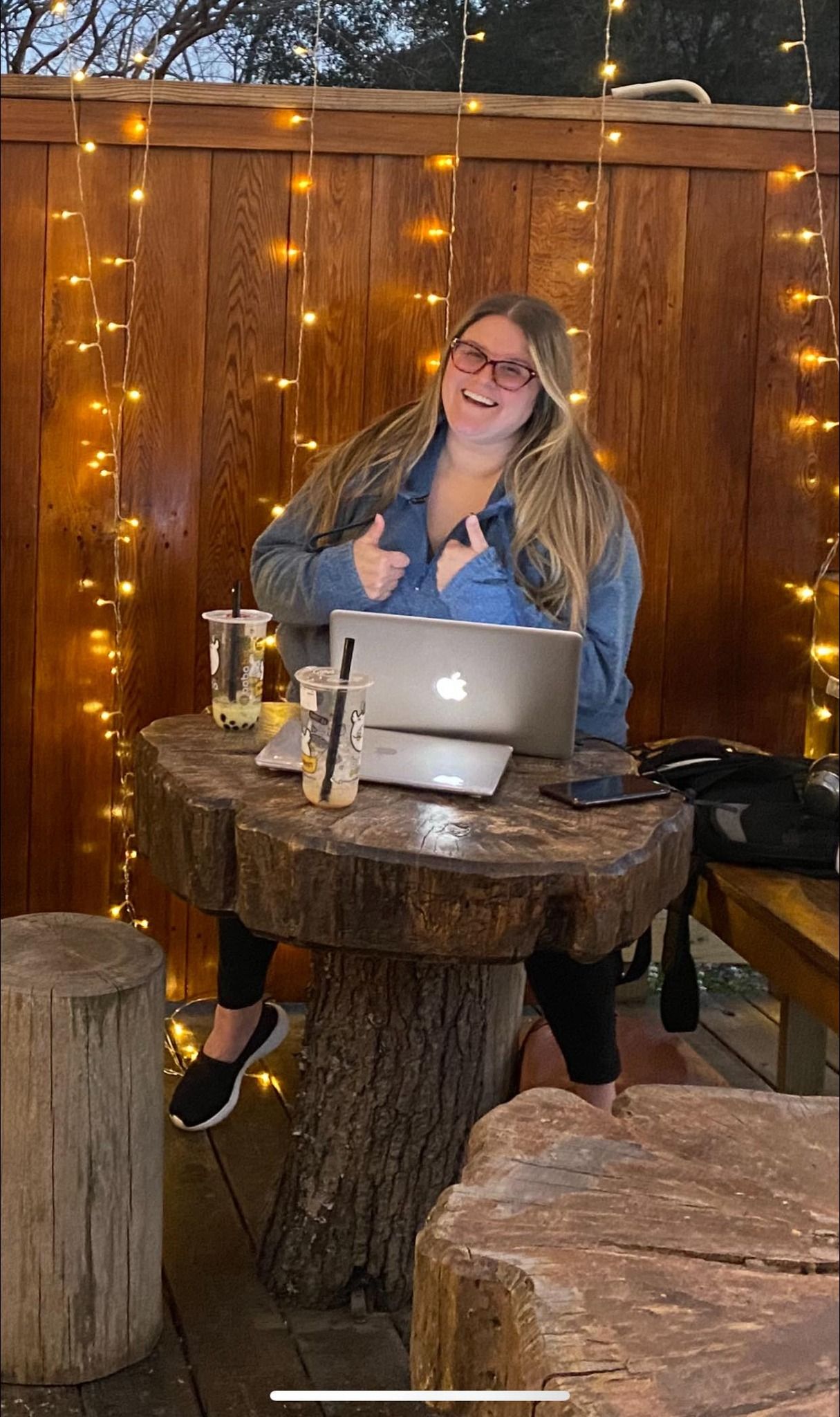 A woman is sitting at a table with a laptop on it.