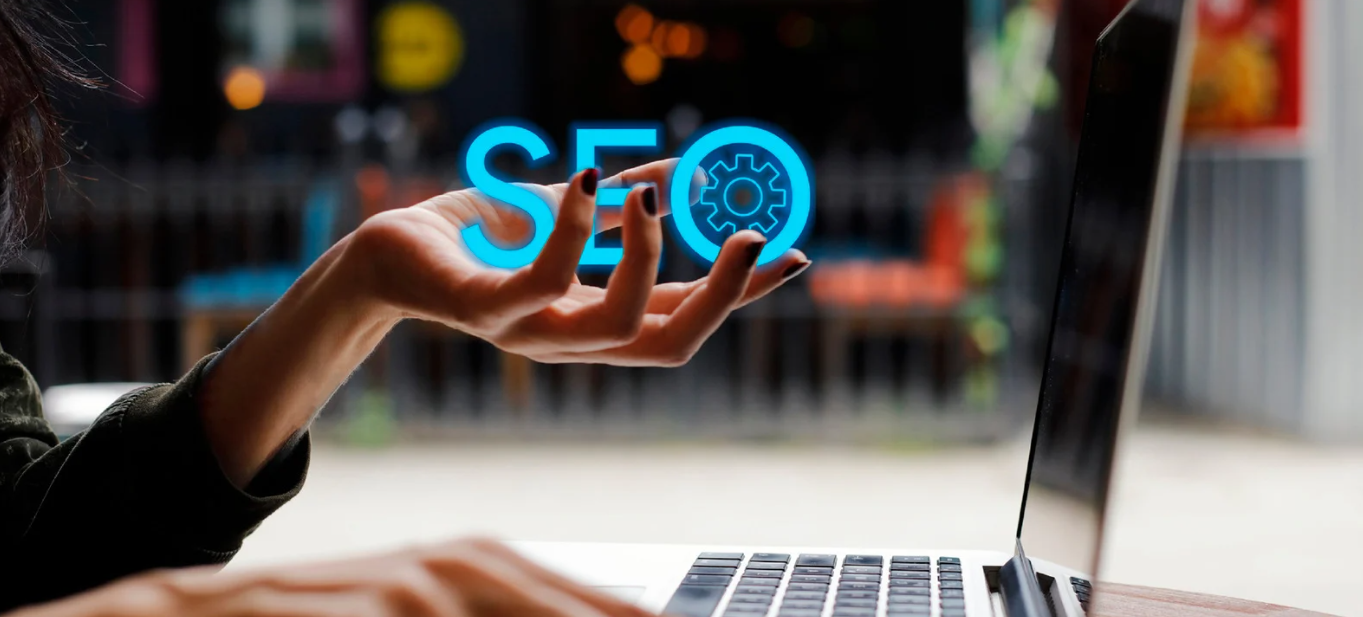 A woman is typing on a laptop computer while holding a sign that says seo.