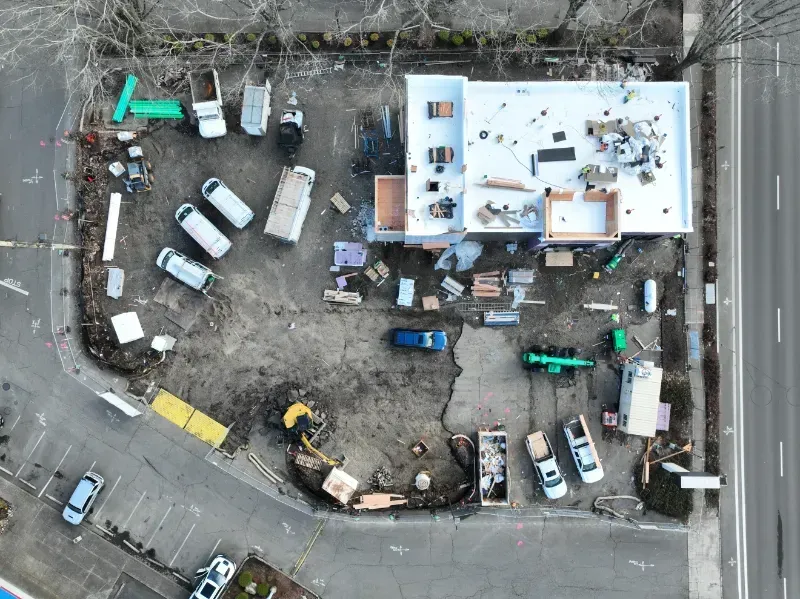 A large hole in the ground in a parking lot with a building in the background in Vancouver, WA