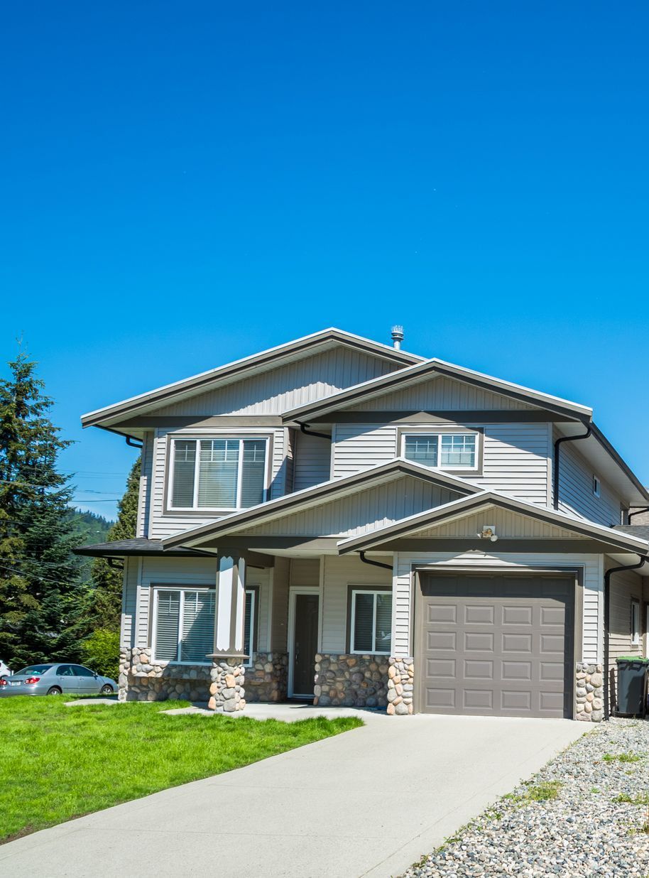 A large house with a large garage and a lush green lawn in Vancouver, WA by NAVA Concrete LLC.