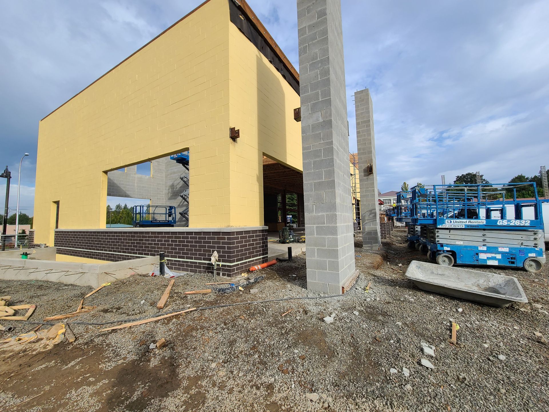 A construction site with a yellow building and a blue crane in Vancouver, WA