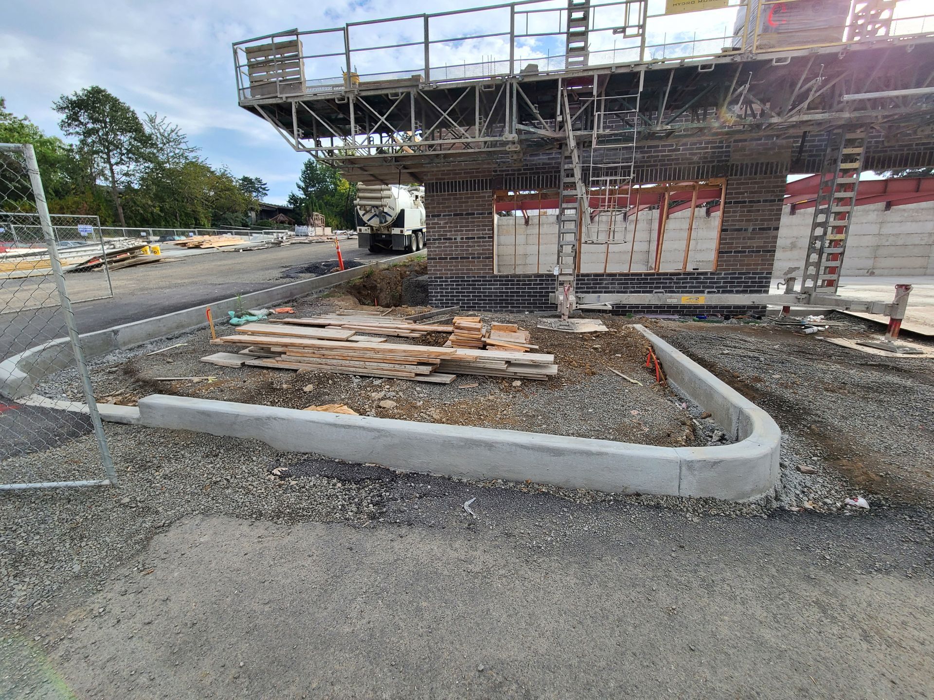 A construction site with a concrete curb in front of a building under construction in Vancouver, WA by NAVA Concrete LLC