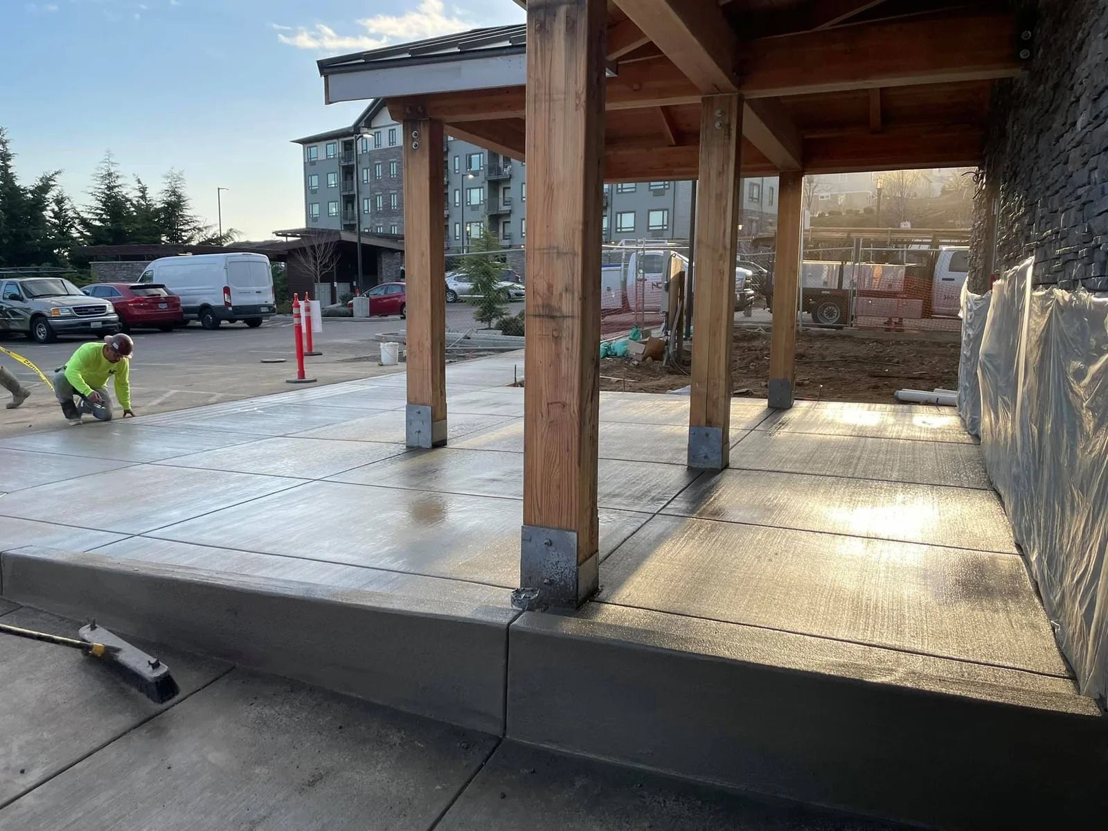 A man is working on a concrete walkway under a wooden structure in Vancouver, WA by NAVA Concrete LLC