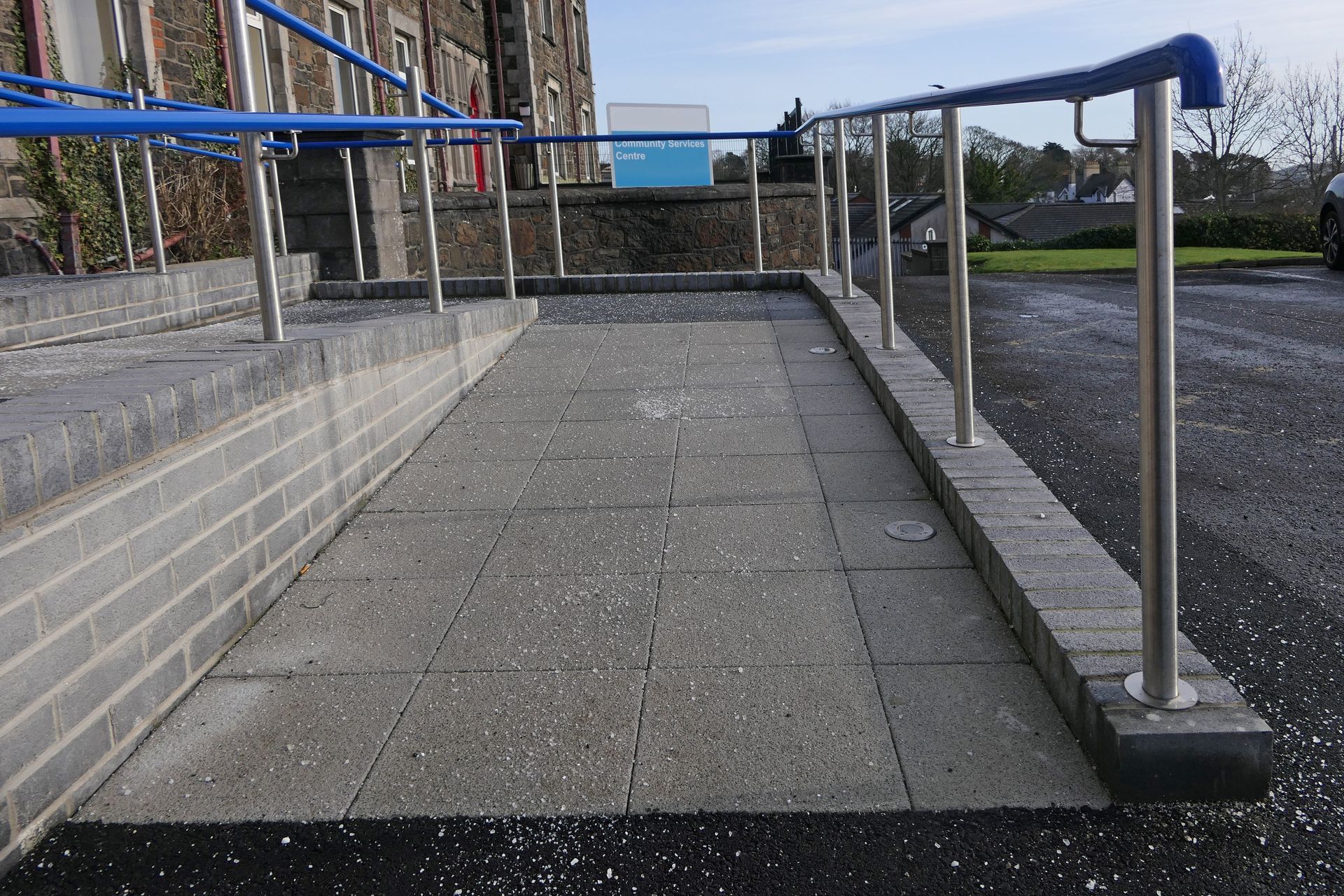 A ramp with a blue railing leading to a building in Vancouver, WA by NAVA Concrete LLC