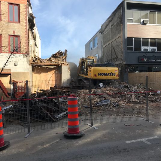 Une excavatrice Komatsu est utilisée pour démolir un bâtiment.