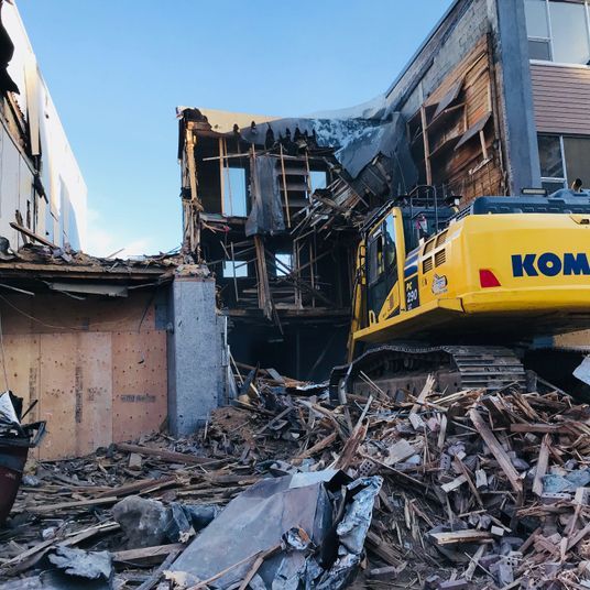 Une excavatrice Komatsu jaune démolit un bâtiment