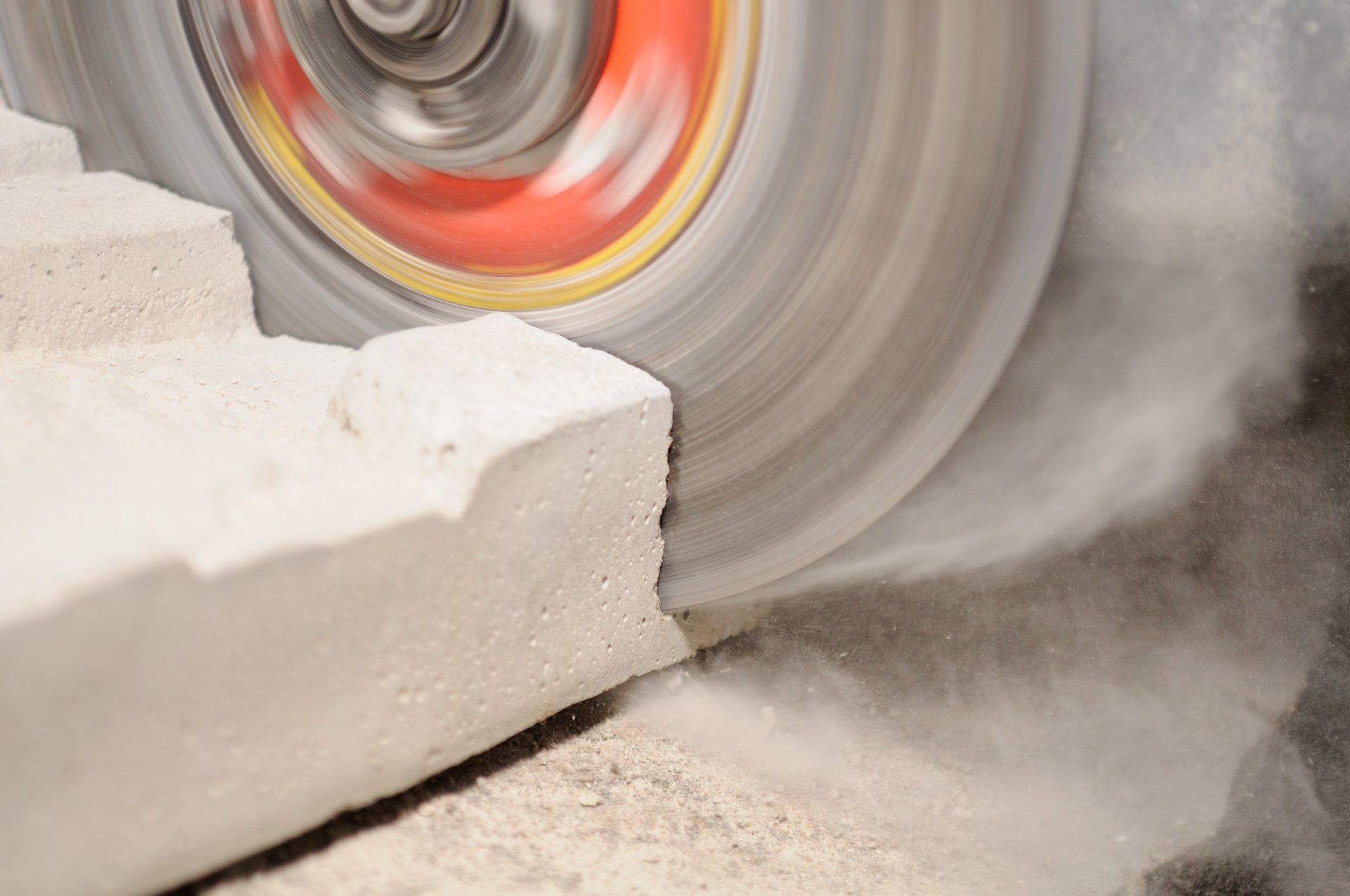 Une scie circulaire coupe un morceau de béton.