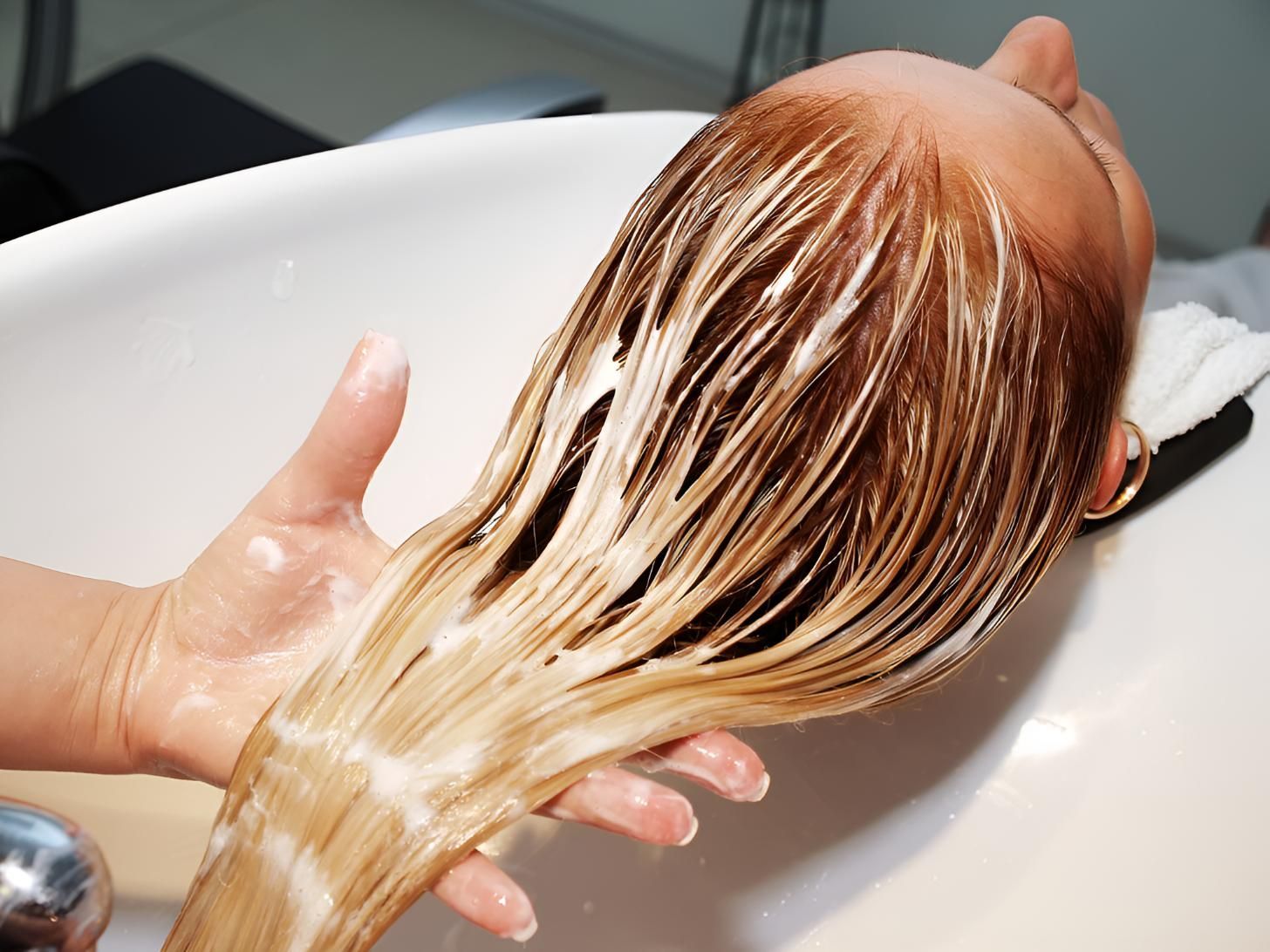 Woman is Washing Her Hair in a White Sink — Lavie Hair & Beauty in Ciccone, NT