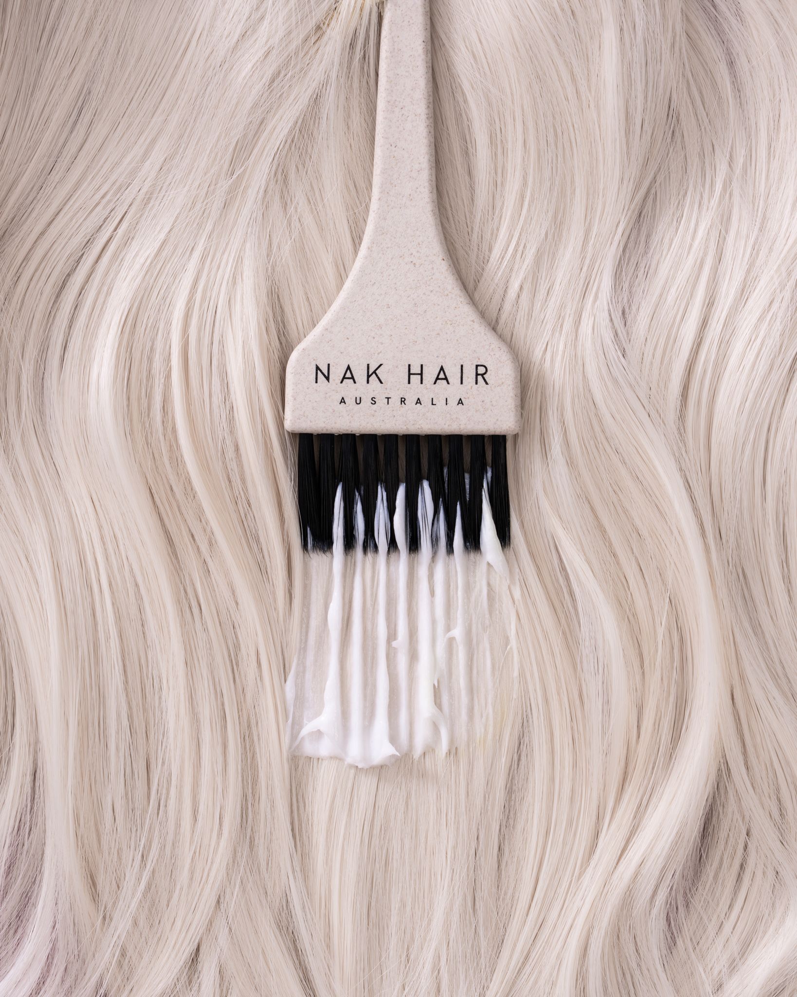 A brush is sitting on top of a piece of white hair — Lavie Hair & Beauty in Ciccone, NT