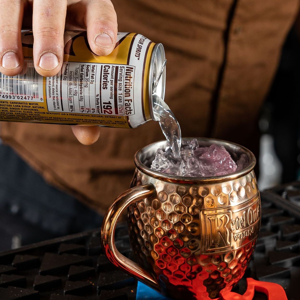 close up image of a person pouring a can into a margarita mug at tony tenderonis