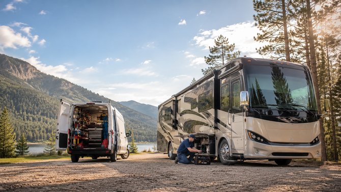 Two RVs parked at a mountain campsite with a person unloading gear.