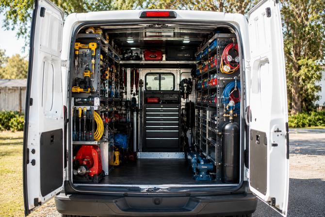 Open cargo van with shelves of tools, hoses, and equipment inside open rear doors.