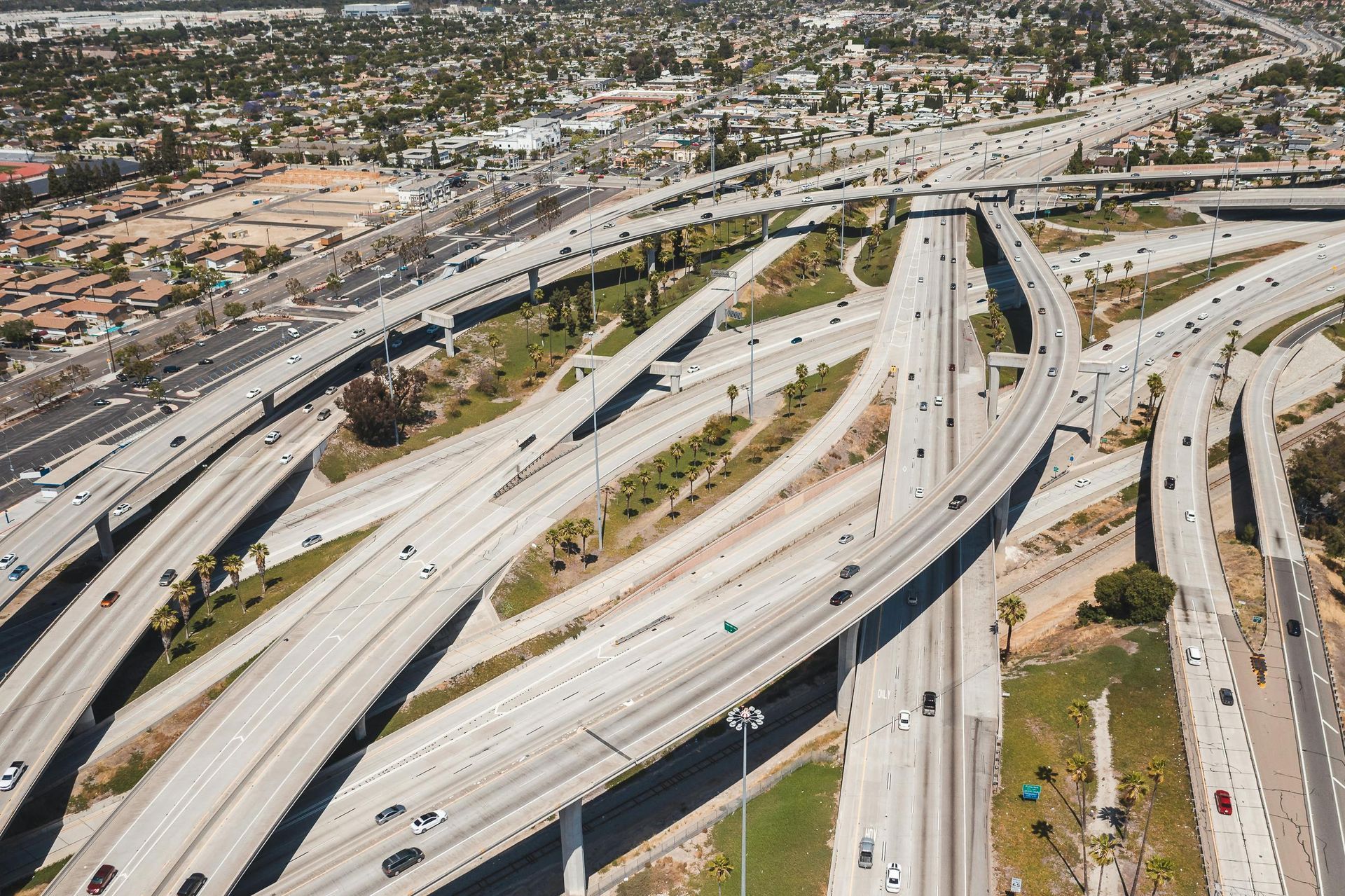 Aerial view of a large freeway interchange with multiple curving highways and light traffic.