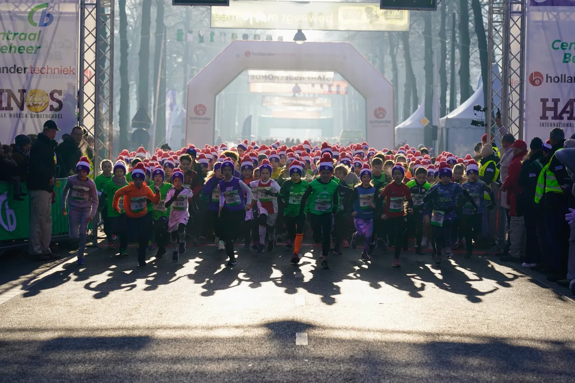 Groep hardlopers Kids Run vertrekt bij de start van de Midwinter Marathon Apeldoorn in de ochtendzon.
©2026-Strikwerda Fotografie