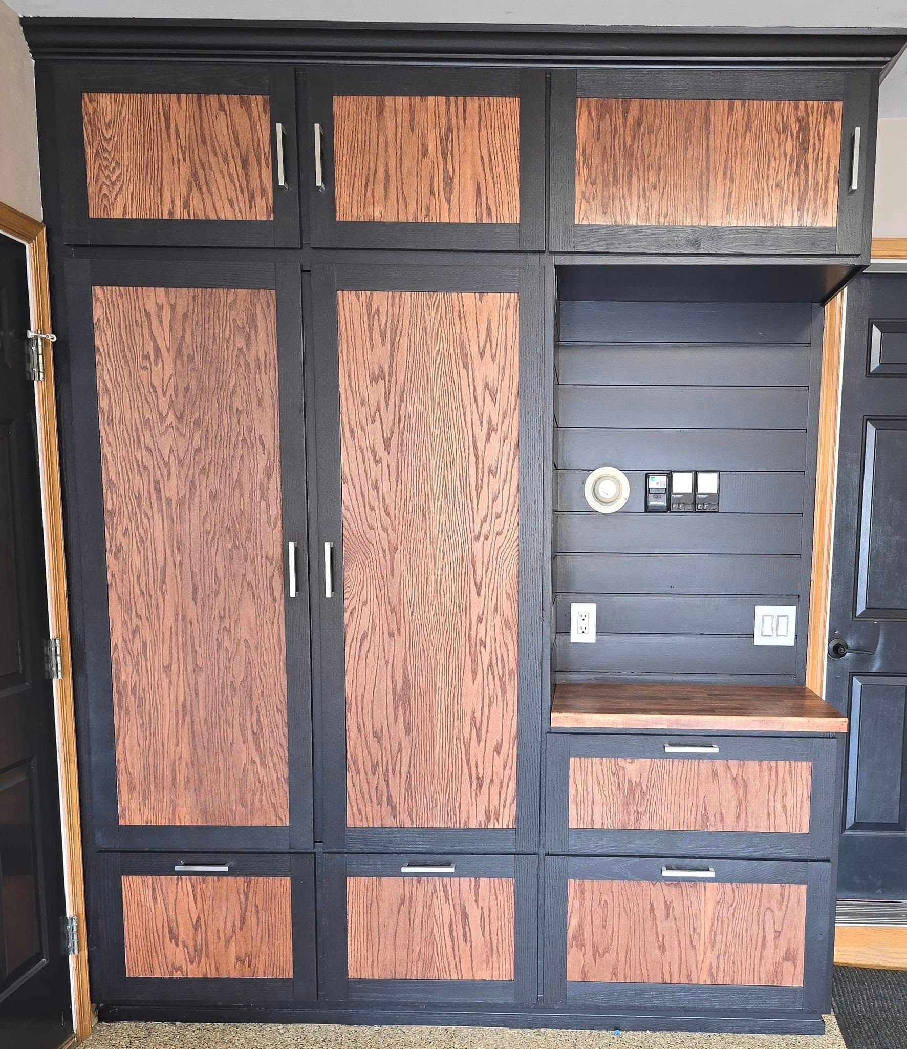 A black cabinet with wooden doors and drawers in a room