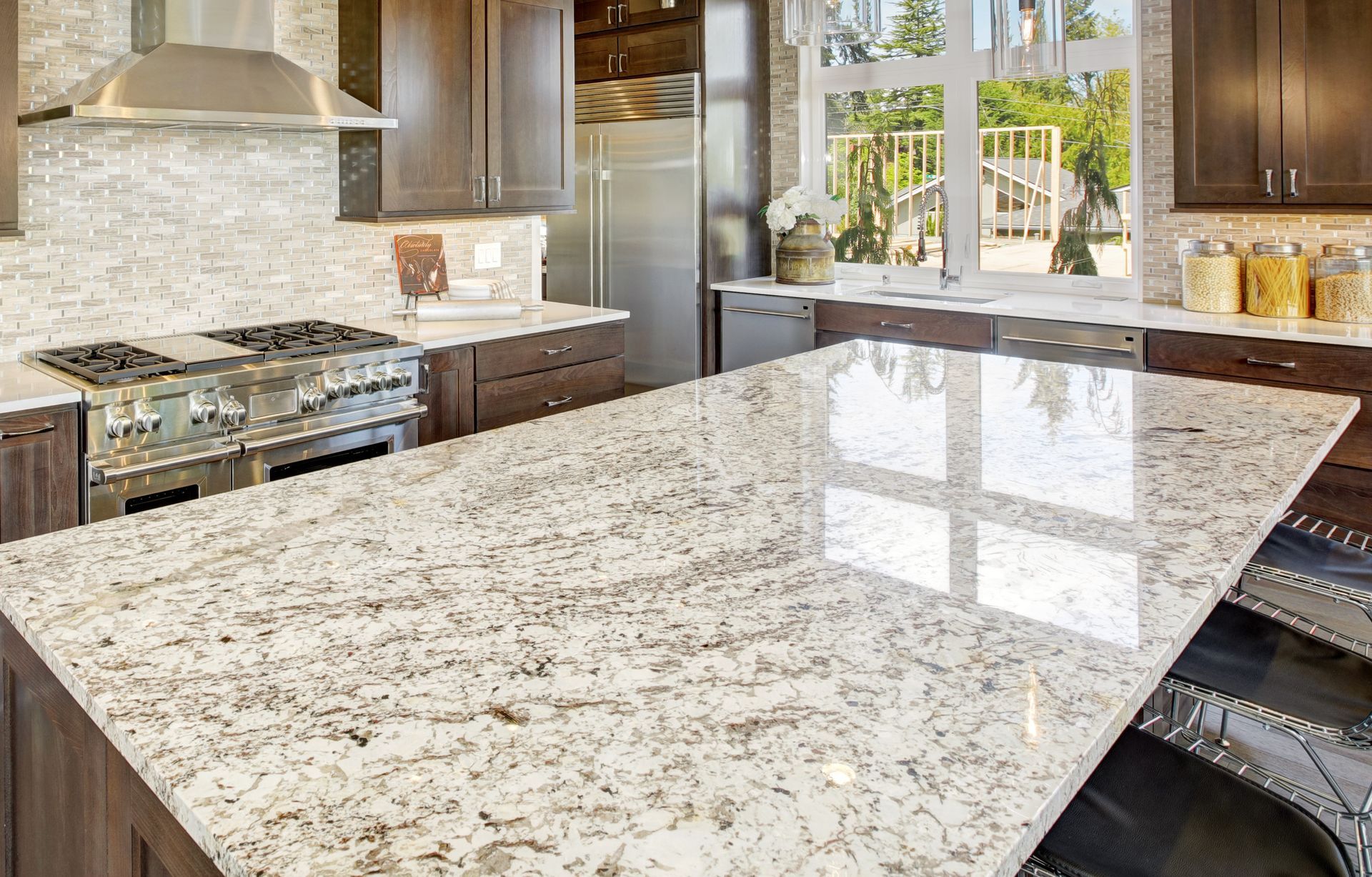 Modern kitchen with a large white-and-gray granite island and stainless steel appliances