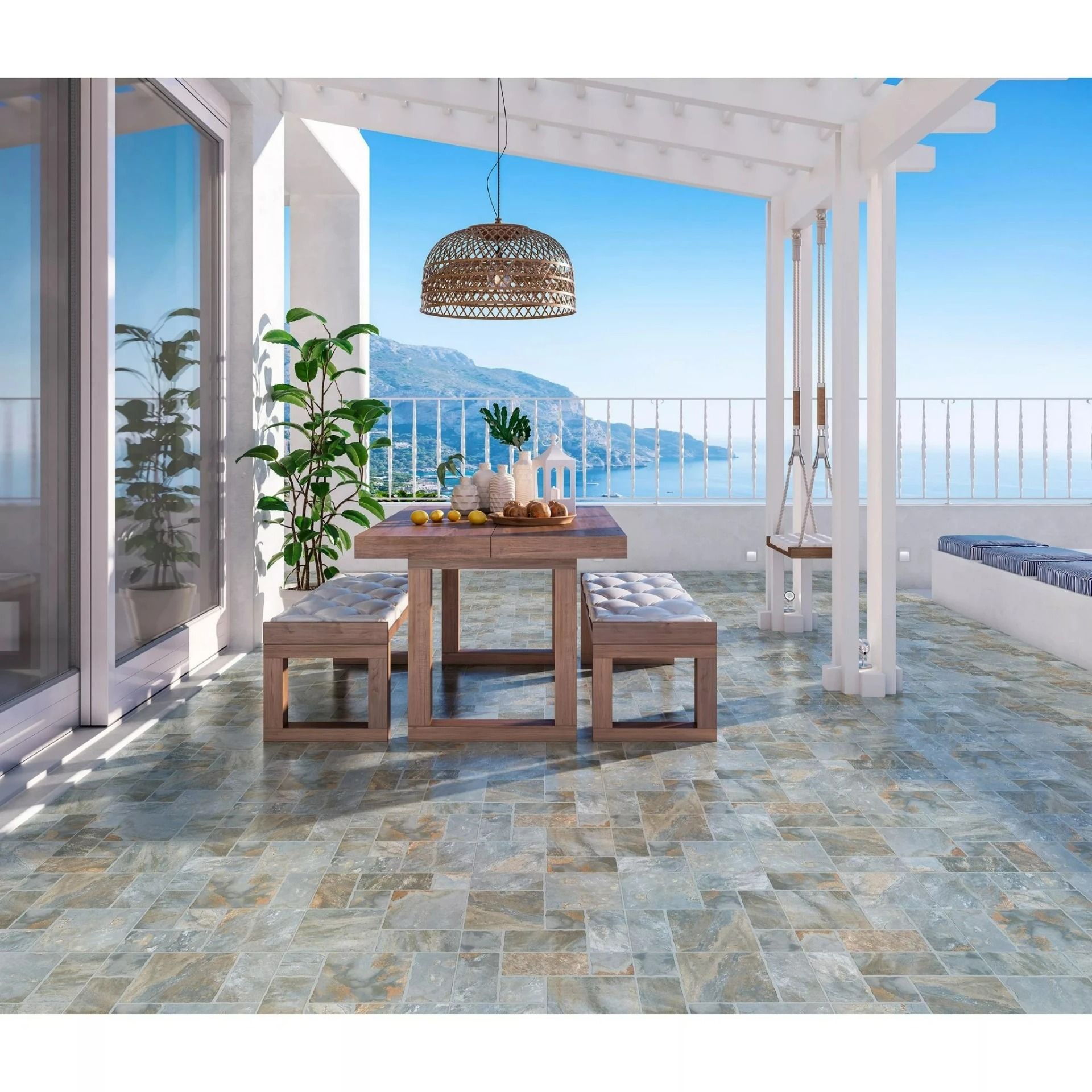 Bright seaside patio with a wooden table, benches, plants, and ocean view under a white pergola