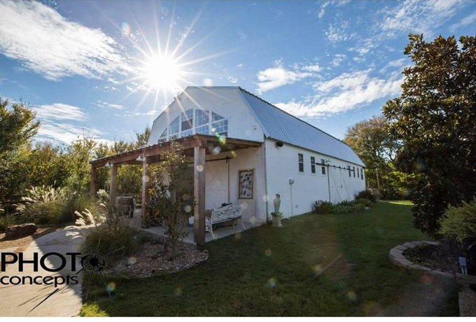 A white barn with the sun shining through the windows