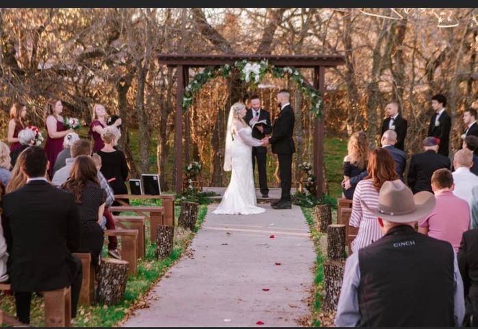 Wedding ceremony: couple under floral arch, guests seated, outdoor setting.
