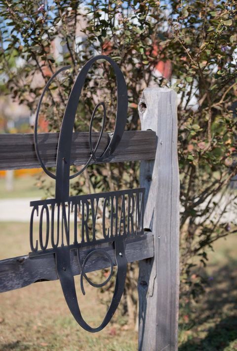 A wooden fence with a metal sign on it.