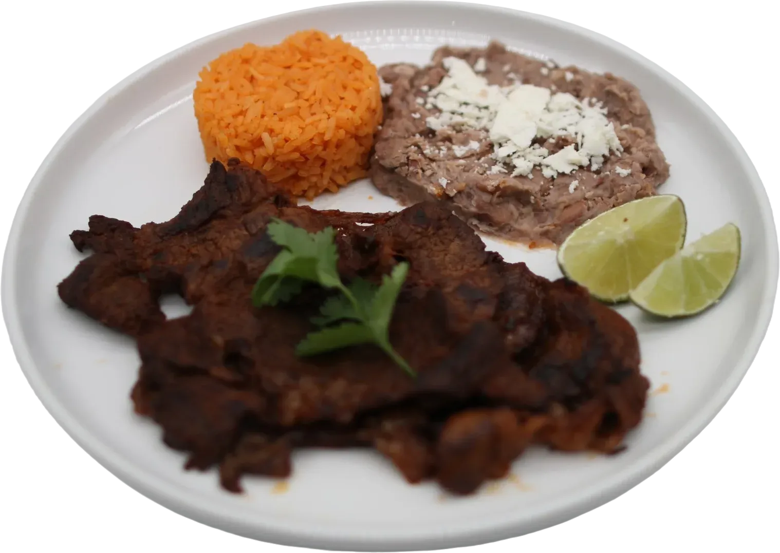 Plate with steak, red rice, refried beans with cheese, and lime slices.
