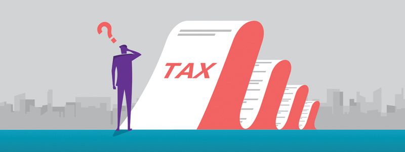 Person beside giant tax form and red pencil with question mark, implying tax confusion