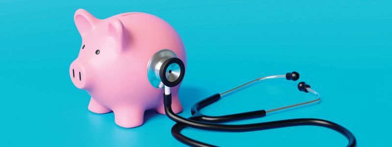 Pink piggy bank with a stethoscope on a blue background.