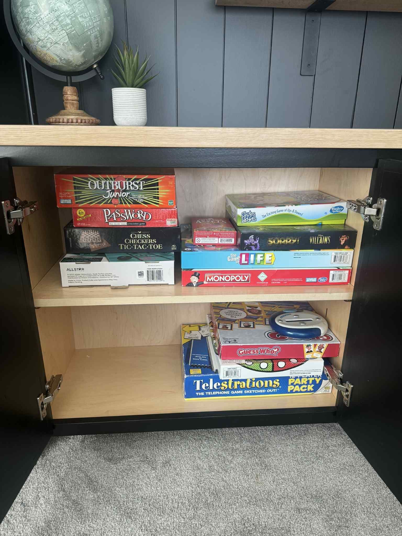 Cabinet filled with various board game boxes.