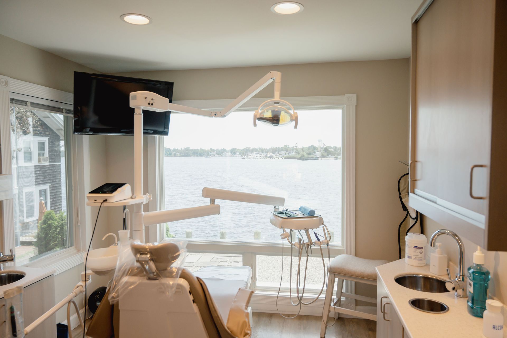 Dental office with chair, instruments, and window overlooking water.