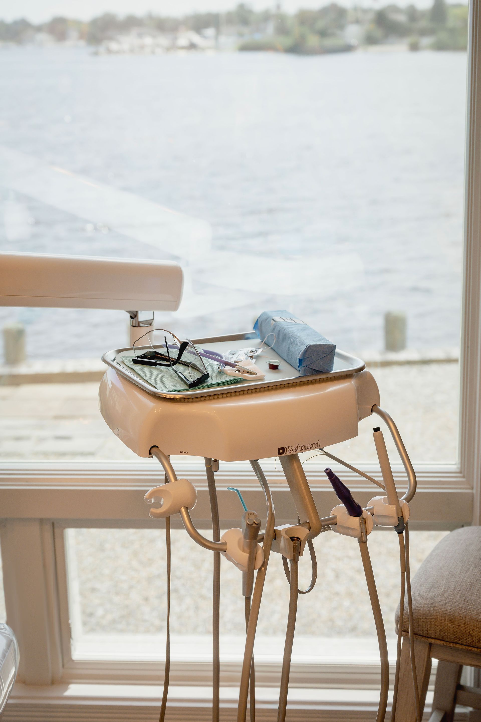 Dental tools and tray near a window overlooking a body of water.