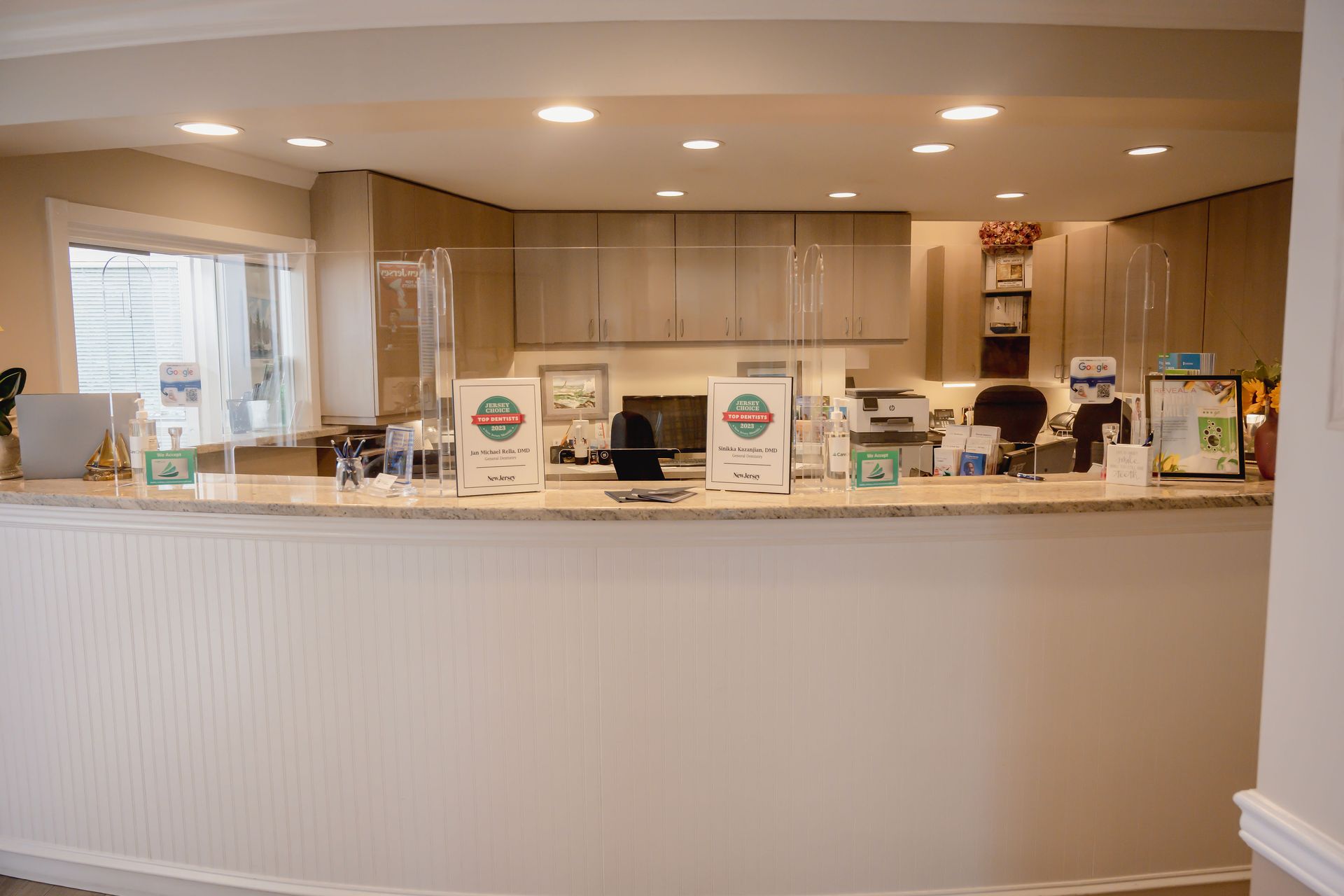 Reception desk with barriers, light cabinets, and countertop.